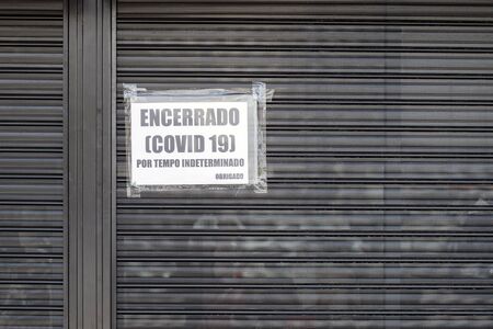 Encerrado (Covid 19) por tempo indeterminado. Obrigada. Information on shop window what translates from portuguese: Closed (Covid 19) for an indefinie period. Thank you.の写真素材