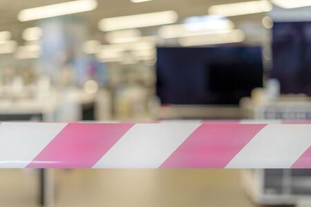 Closed appliance store with security tape in the foreground. Result of coronavirus pandemic.の写真素材