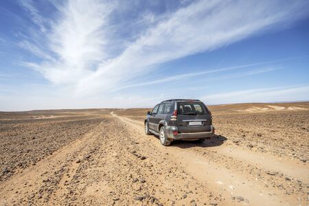 Driving 4x4 car on dirt road through Sahara desert, Moroccoの写真素材