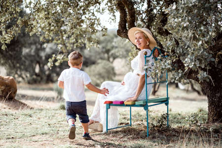 Pregnant woman spending time with her little son in the natureの写真素材