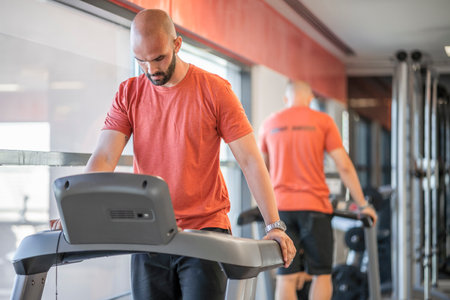 A man preparing himself for a treadmill run at the gymの写真素材