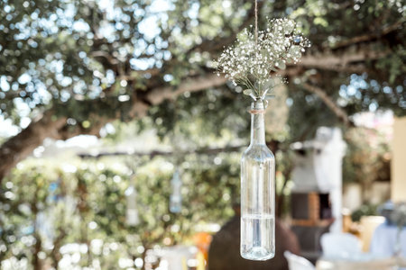 Rustic wedding decoration - gypsophila in bottle hanging on the treeの写真素材