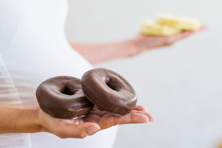 Pregnant woman hesitating between donuts and slices of pineappleの写真素材