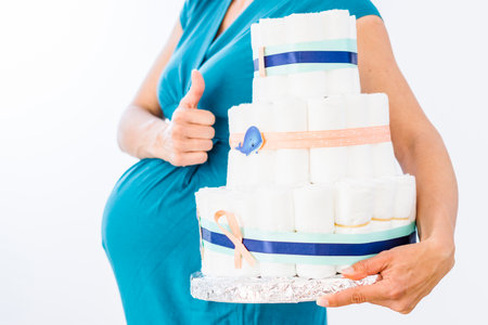 Pregnant woman holding diaper cake for her unborn boyの写真素材