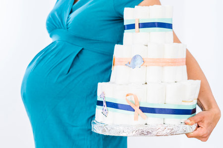 Pregnant woman holding diaper cake for her unborn boyの写真素材