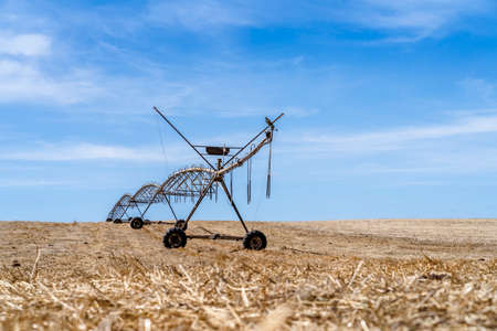 Moving irrigation system standing on a dry stubble field in Alentejo, Portugalの写真素材
