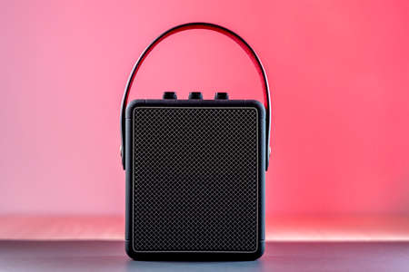 Black modern bluetooth loudspeaker on a pinkish backgroundの写真素材