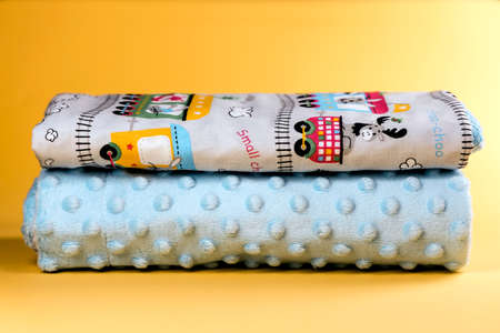 Sweet and cozy baby blanket with train pattern isolated on yellow backgroundの写真素材