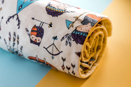 Sweet and cute baby blanket with Indian pattern isolated on yellow and blue backgroundの写真素材