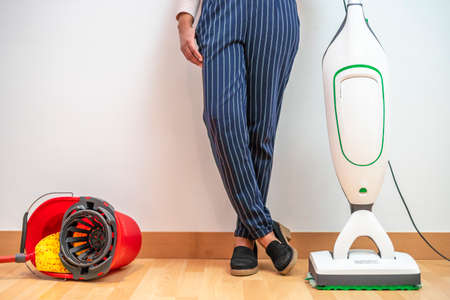 Woman prefers modern electric mop combined with vacuum cleaner than old bucket and mopの写真素材