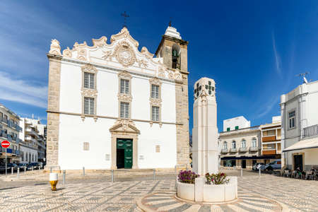 Square with white, old church and monument in Olhao, Algarve, Portugalの写真素材