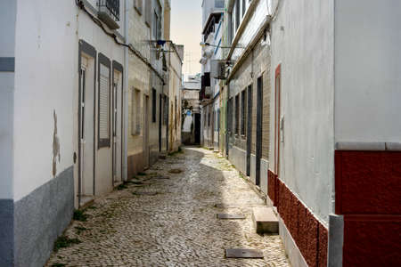 Narrow street of historic fishermen's town called Olhao, Algarve, Portugalの写真素材
