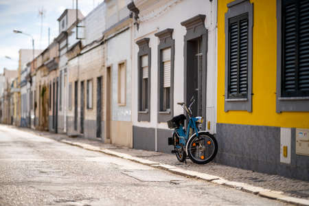 Vintage motorbike parked by typical fisherman's house in Olhao, Algarve, Portugalの写真素材