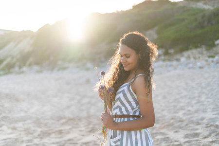 Portrait of a beautiful young woman on the beach by sunset in Algarve, Portugalの写真素材