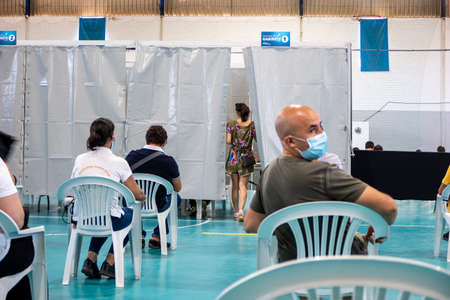 Olhao, Portugal - June 30, 2021: People waiting in the waiting room before getting Covid 19 vaccine in Vaccination Centerのeditorial素材