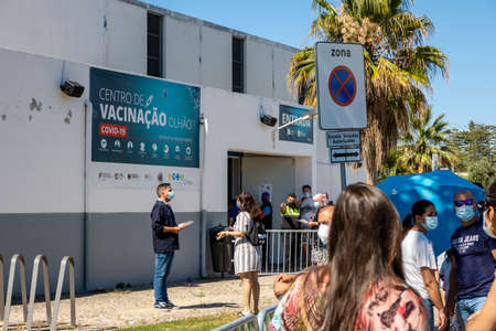 Olhao, Portugal - June 30, 2021: Many people in the line waiting for Covid-19 vaccine in front of Vaccination Centerのeditorial素材