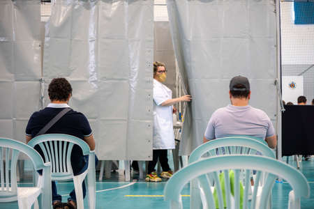 Olhao, Portugal - June 30, 2021: People waiting in the waiting room before getting Covid 19 vaccine in Vaccination Centerのeditorial素材