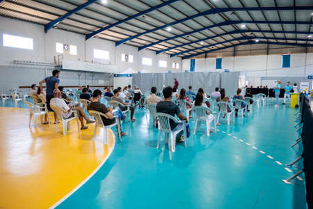Olhao, Portugal - June 30, 2021: People waiting in the waiting room before getting Covid 19 vaccine in Vaccination Centerのeditorial素材