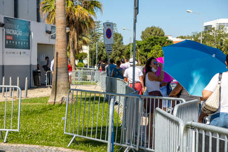 Olhao, Portugal - June 30, 2021: Many people in the line waiting for Covid-19 vaccine in front of...