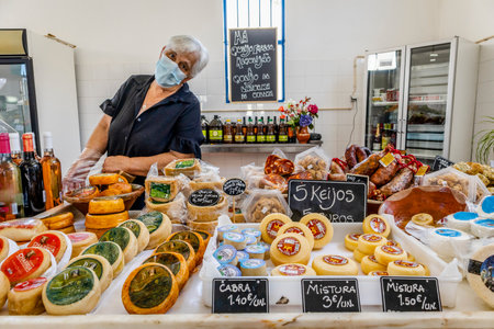 Zambujeira do Mar, Portugal - June 28, 2021: Sellers at municipal market with local products as cheeses, meats, wines, and moreのeditorial素材