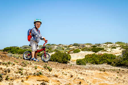 3 years old boy on his bicycle ready for adventure in natureの写真素材