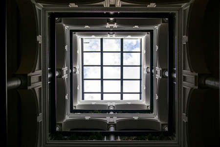 Interior of the small courtyard covered with glass in an old renovated tenement house in Spainの写真素材