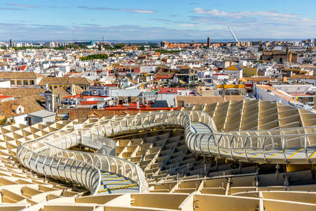 Seville skyline with wooden roof with walkways called Setas de Sevilla in the foreground, Andalusia, Spainの写真素材