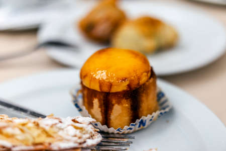 Small Spanish sweet pastry served with another delicious dessert on white plate in Seville, Andalusia.の写真素材