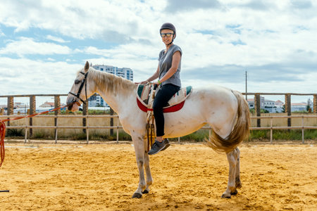 Portrait of a woman taking horse riding lessons in a paddockの写真素材