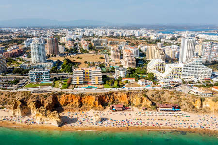 Aerial view of touristic Portimao with wide sandy Rocha beach full of people, Algarve, Portugalの写真素材