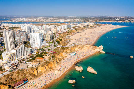 Aerial view of touristic Portimao with wide sandy Rocha beach full of people, Algarve, Portugalの写真素材