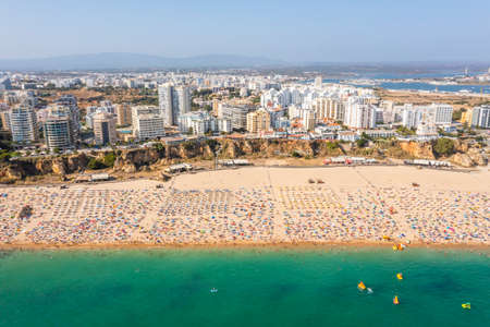 Aerial view of touristic Portimao with wide sandy Rocha beach full of people, Algarve, Portugalの写真素材