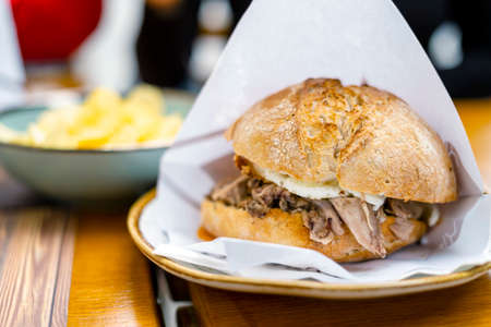 Delicious bun with delicate piglet and egg with chips aside, Portugalの写真素材