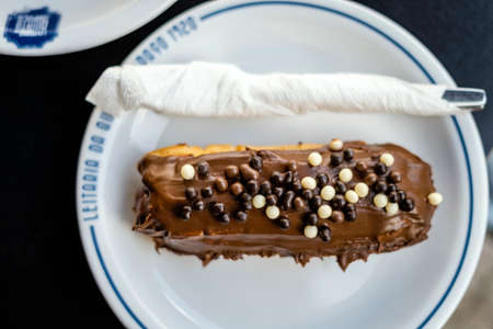Porto, Portugal - September 25, 2021: Tasty eclair pastry filled and covered with chocolate in Leitaria da Quinta do paÃ§oの写真素材