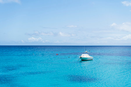 Small yacht on turquoise sea under blue sky in Punta Mujeres, Lanzarote, Canary Islands, Spainの写真素材