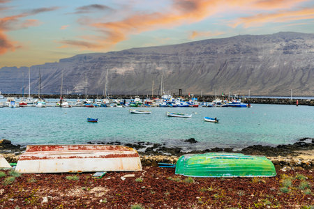 View of port, boats on the shore and volcanic Lanzarote Island in the background, Caleta del Sebo, La Graciosa, Canary Islands, Spainの写真素材