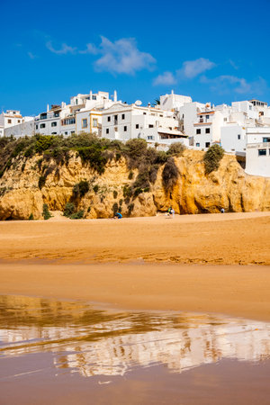 Great view of Fisherman Beach, Praia dos Pescadores, with whitewashed houses on cliff, reflecting on the sea, blue sky, summer time, Albufeira, Algarve, Portugalの写真素材