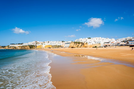 Great view of Fisherman Beach, Praia dos Pescadores, with whitewashed houses on cliff, reflecting on the sea, blue sky, summer time, Albufeira, Algarve, Portugalの素材 [FY310204819648]