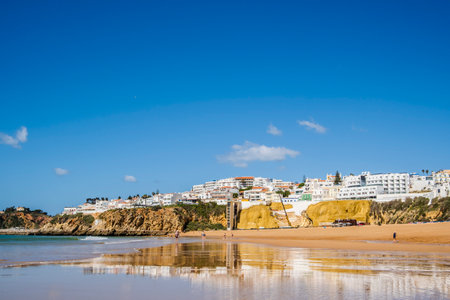 Great view of Fisherman Beach, Praia dos Pescadores, with whitewashed houses on cliff, reflecting on the sea, blue sky, summer time, Albufeira, Algarve, Portugalの写真素材