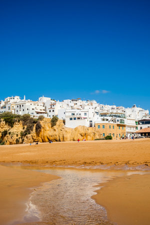 Great view of Fisherman Beach, Praia dos Pescadores, with whitewashed houses on cliff, reflecting on the sea, blue sky, summer time, Albufeira, Algarve, Portugalの写真素材