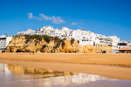Great view of Fisherman Beach, Praia dos Pescadores, with whitewashed houses on cliff, reflecting on the sea, blue sky, summer time, Albufeira, Algarve, Portugalの写真素材