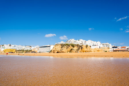 Great view of Fisherman Beach, Praia dos Pescadores, with whitewashed houses on cliff, reflecting on the sea, blue sky, summer time, Albufeira, Algarve, Portugalの写真素材