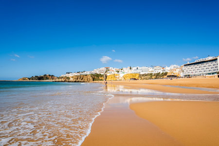 Great view of Fisherman Beach, Praia dos Pescadores, with whitewashed houses on cliff, reflecting on the sea, blue sky, summer time, Albufeira, Algarve, Portugalの写真素材