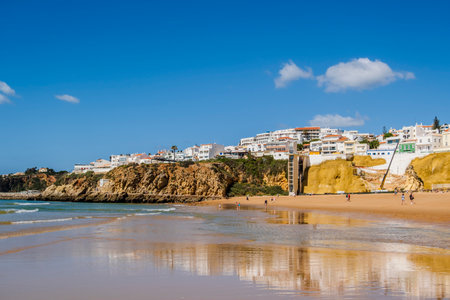 Great view of Fisherman Beach, Praia dos Pescadores, with whitewashed houses on cliff, reflecting on the sea, blue sky, summer time, Albufeira, Algarve, Portugalの写真素材