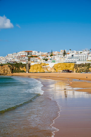 Great view of Fisherman Beach, Praia dos Pescadores, with whitewashed houses on cliff, reflecting on the sea, blue sky, summer time, Albufeira, Algarve, Portugalの写真素材
