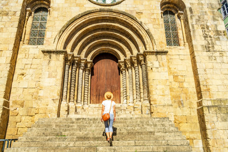 Woman visiting a Romanesque church, Coimbra, Igreja de Sao Tiagoの写真素材