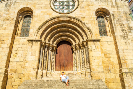 Woman visiting a Romanesque church, Coimbra, Igreja de Sao Tiagoの写真素材