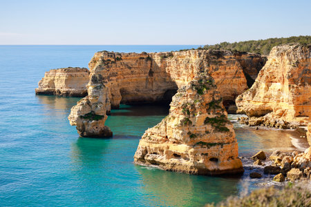 Beautiful cliffs and rock formations by the Atlantic Ocean at Marinha Beach in Algarve, Portugalの写真素材