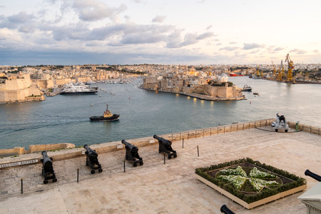 Beautiful sunset view of Valletta with a cannons in the foreground, capital city of Maltaの写真素材