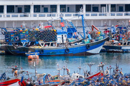 Rabat, Morocco â A scenic view of the Bou Regreg River with colorful fishing boats gently floating on the water, and the historic Hassan Tower rising in the background. Captured on a clear, sunny day, this image showcases the blend of tradition and modern life in Morocco's capital city, highlighting its rich history, vibrant culture, and picturesque waterfront.の写真素材